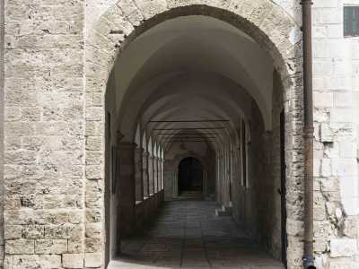 Attraverso un arco situato accanto alla facciata della chiesa, abbiamo accesso al monastero maschile, la cui prima pietra si dice sia stata posta da San Francesco in persona il 30 marzo del 1220, mentre era di ritorno dalla Terra Santa